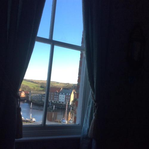 a window with a view of a river and buildings at Abbey and Esk Bed and Breakfast in Whitby