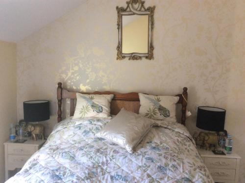 a bedroom with a bed with a mirror on the wall at Abbey and Esk Bed and Breakfast in Whitby