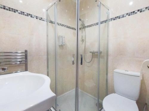 a bathroom with a shower and a toilet and a sink at Apple Garden A-3 in London