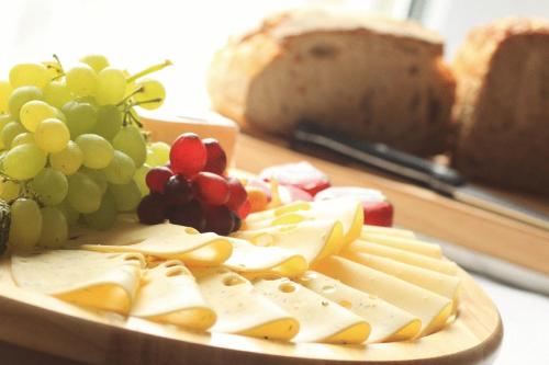 a plate of cheese and grapes and a loaf of bread at Klozbücher - Das Landhotel in Ellwangen