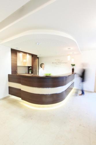 a man standing at a bar in a building at Klozbücher - Das Landhotel in Ellwangen
