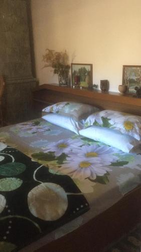 a bed with flowers on it in a bedroom at Vila Licurici in Caciulata