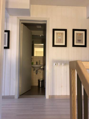a hallway with a sink and a mirror at Marių pelėdos in Preila
