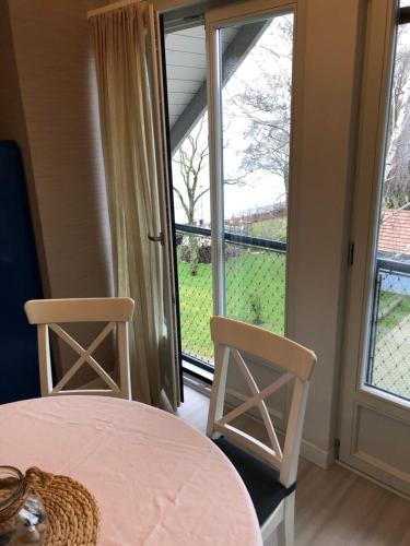 a room with a table and two chairs and a window at Marių pelėdos in Preila