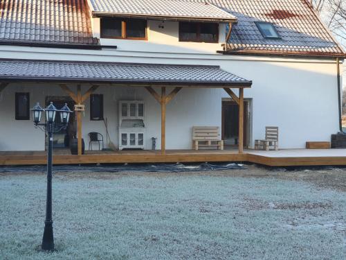 a house with a porch and a street light in front of it at Noclegi i sauna w starym domu in Pławnica