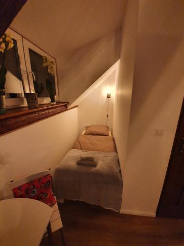 a small room with a bed in a attic at Noclegi i sauna w starym domu in Pławnica