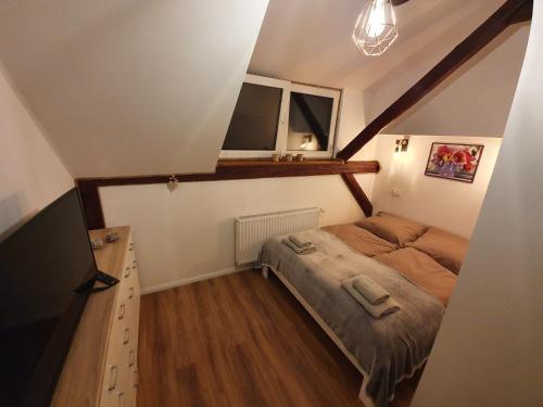 a small bedroom with a bed and a window at Noclegi i sauna w starym domu in Pławnica