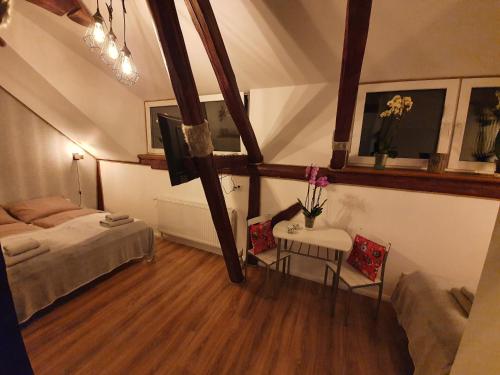 a bedroom with a bed and a table and chairs at Noclegi i sauna w starym domu in Pławnica