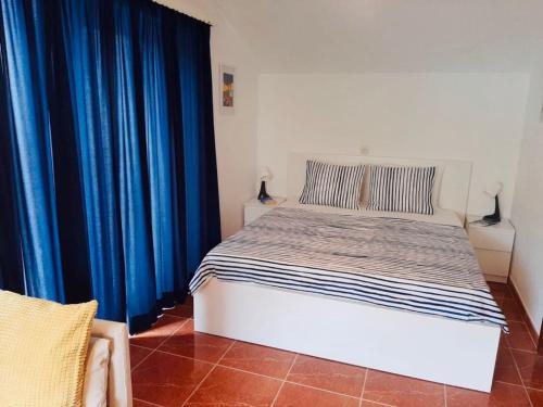 a bedroom with a bed with blue drapes at Apartments Barbaresko in Lumbarda