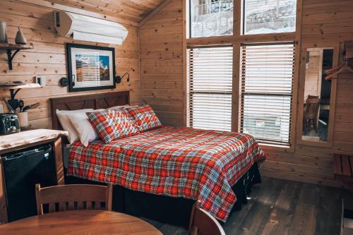 a bedroom with a bed and a table in a cabin at Tiny Homes at Powderhorn Mountain Resort in Mesa