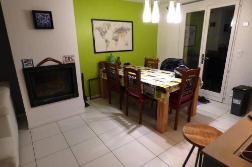 un salon avec une table, des chaises et une télévision dans l'établissement Villa spacieuse lumineuse à Paris, à Argenteuil