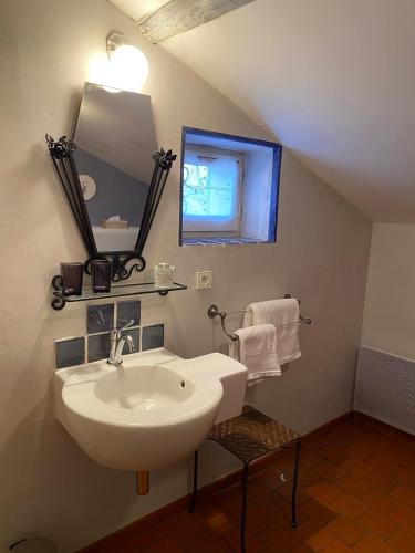 une salle de bain avec un lavabo blanc et un miroir dans l'établissement Le Mas de la Martelière, au Thor