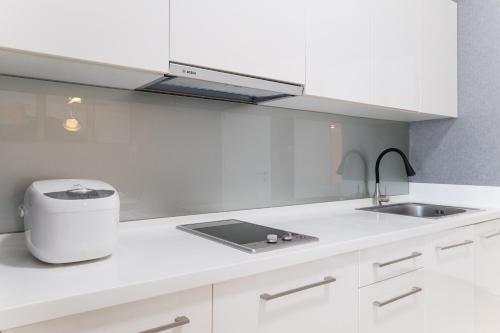 a kitchen with white cabinets and a sink at Madam Design 2 at Kota Damansara in Petaling Jaya