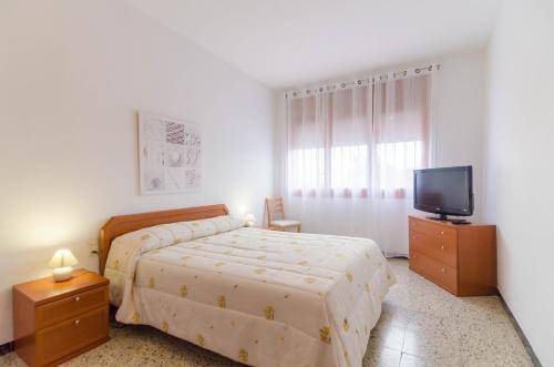 a bedroom with a bed and a flat screen tv at Club Villamar - Aygo in Maçanet de la Selva
