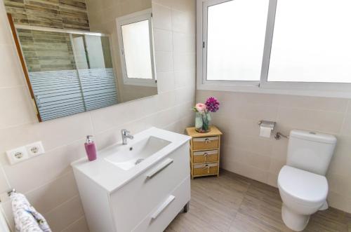 a bathroom with a sink and a toilet and a mirror at Club Villamar - Aygo in Maçanet de la Selva