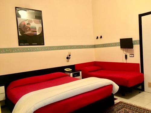 a bedroom with a red bed and a couch at Hotel Letizia in Orte
