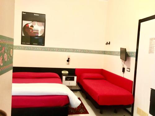 a bedroom with a red bed and a red couch at Hotel Letizia in Orte