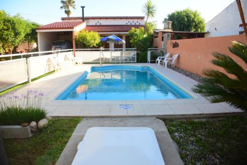 una piscina en un patio con una casa en Departamentos MeliMar en Miramar