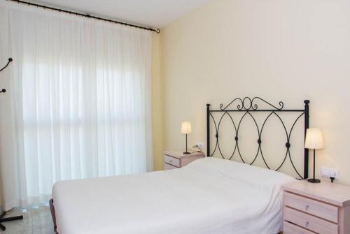 Un dormitorio con una gran cama blanca y una ventana en Club Villamar - Juny en Cubelles
