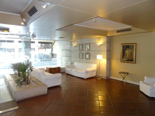 una sala de estar con 2 sofás blancos y una mesa. en Arenales Apartamento en Buenos Aires