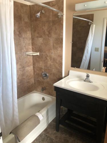 a bathroom with a sink and a tub and a shower at Meadowcliff Lodge Coleville in Coleville