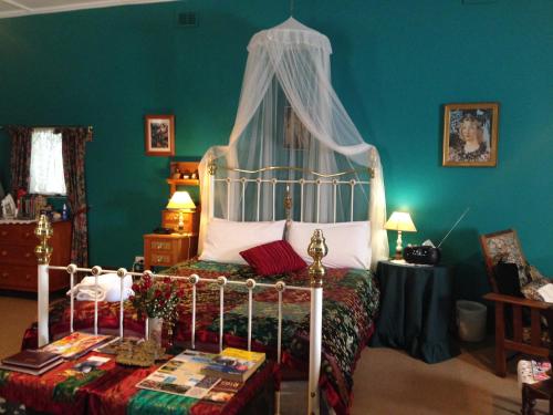 Bethany Cottages في Bethany: غرفة نوم بسرير مع مظلة