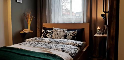 a bedroom with a bed with pillows and a window at Centrum Kupiecka Apartment in Zielona Góra