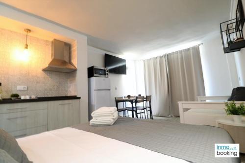 a bedroom with a bed and a kitchen and a table at Experience Internacional Salou - Climatizado con piscina in Salou