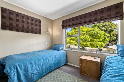 2 camas en un dormitorio con ventana en Taha Wai - Wanaka Holiday Home, en Wanaka