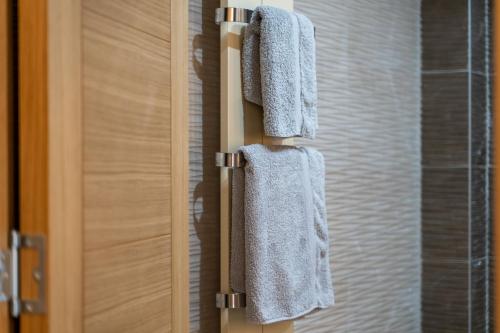 un par de toallas colgando de una puerta en un baño en Apartment Imperial in Vila Pekovic Green, en Zlatibor