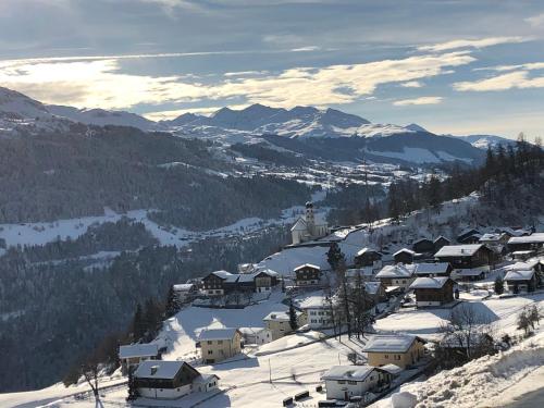 a snow covered village with a church on a mountain at Bijou Ladir in Ladir