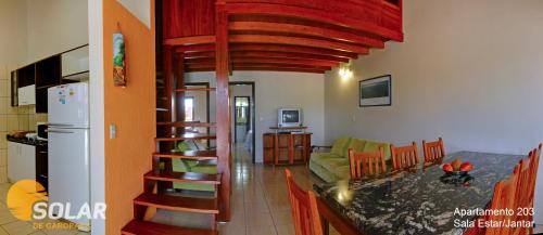 a kitchen and a living room with a spiral staircase at Solar de Garopaba in Garopaba