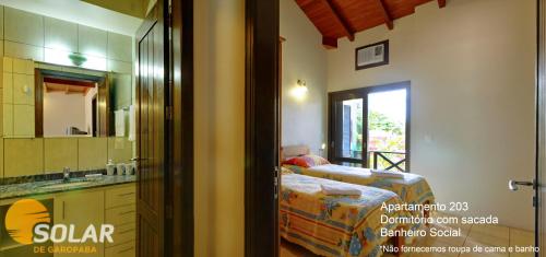 a bedroom with a bed and a sink and a mirror at Solar de Garopaba in Garopaba