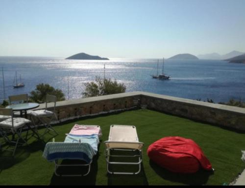 a patio with chairs and a table with a view of the water at Aegean Blue in Panteli