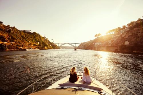 two girls sitting on the back of a boat in the water at Porto Private Yacht- Accommodation Douro River in Porto