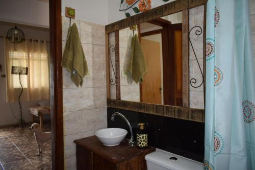 une salle de bain avec un lavabo et un miroir dans l'établissement Casa do campo, à Ibitipoca