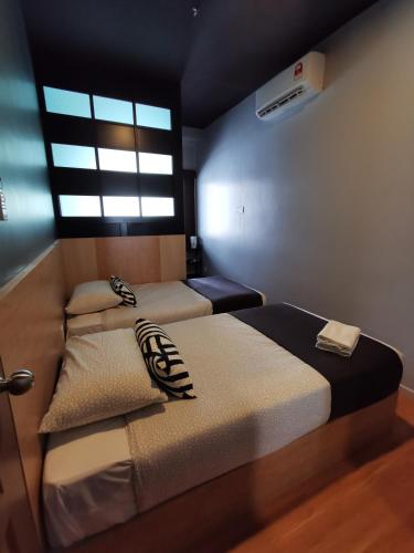 two beds in a small room with a window at Tatami D'Tepi Laut - PANGKOR ISLAND in Pangkor