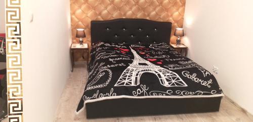 a bed with a black bedspread with the eiffel tower at Apartament centrum Sienkiewicza WIEŻA EIFFLA PROMENADA -KLIMATYZACJA- WYJĄTKOWY in Kielce