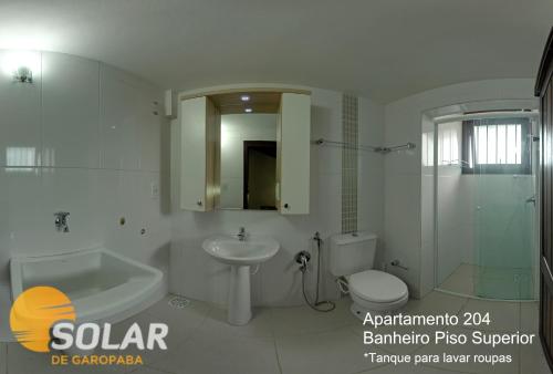 a bathroom with a sink and a toilet and a shower at Solar de Garopaba in Garopaba