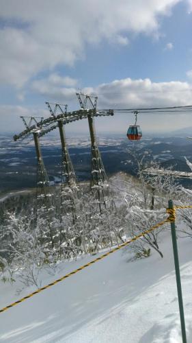 a ski lift on top of a snow covered mountain at Santari in Shintoku