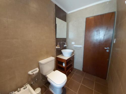 a bathroom with a toilet and a sink and a door at Linda Vista en Adrogue in Adrogué