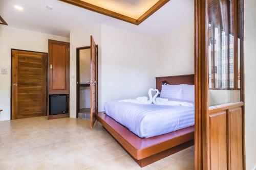 a bedroom with a bed with a wooden frame at Wyh Hotels in Koh Tao