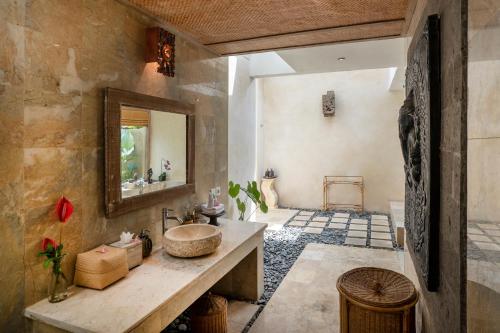 a bathroom with a sink and a mirror at Puri Gangga Resort Ubud in Tegalalang