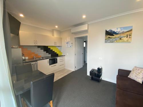 a kitchen and living room with a couch and a table at BigSky Motels in Omarama