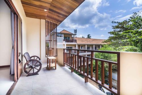 a balcony with a view of a house at Wyh Hotels in Koh Tao