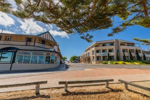 a bench in front of a street with buildings at Aurora Ozone Hotel Kangaroo Island in Kingscote