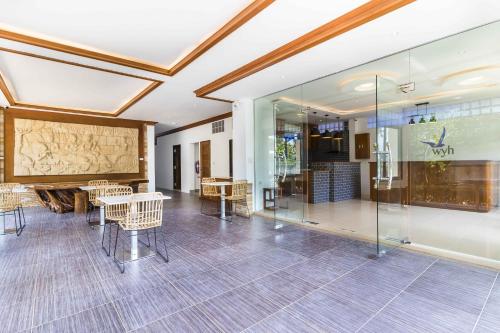 a room with chairs and tables and a glass wall at Wyh Hotels in Koh Tao