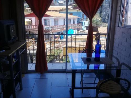 a table with a bottle on it in front of a window at Habitaciones Gabriel in Horcón
