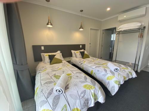 two beds sitting next to each other in a bedroom at BigSky Motels in Omarama