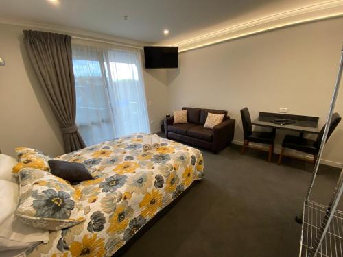 a bedroom with a bed and a chair and a desk at BigSky Motels in Omarama